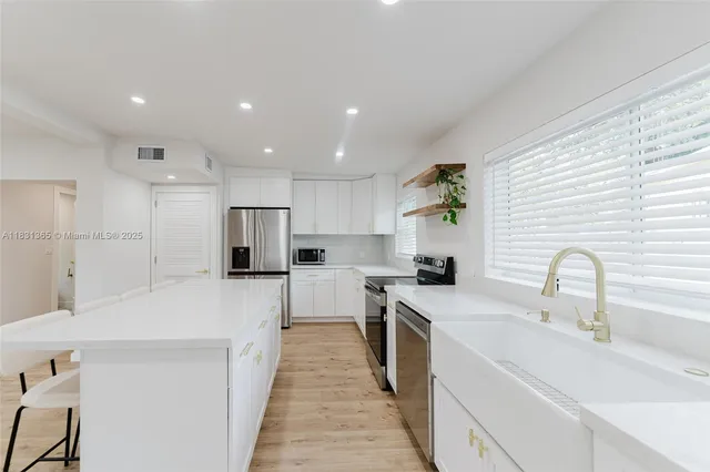 a kitchen with white cabinets stove and refrigerator