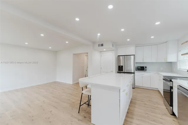 a kitchen with stainless steel appliances a refrigerator sink and microwave