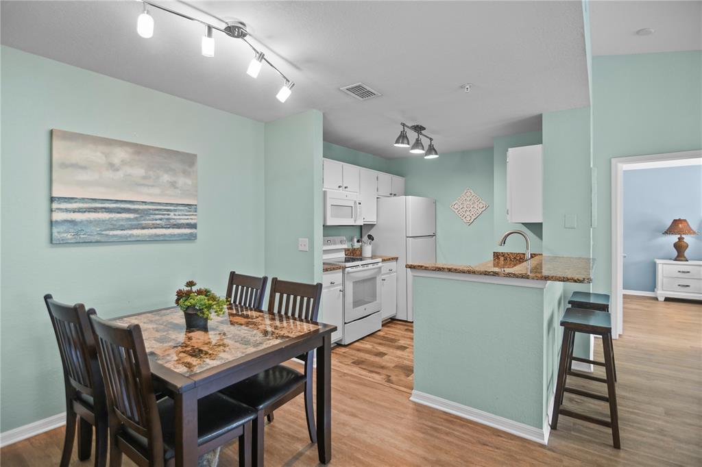 7417 Vista Way, Unit 202 Lakewood Ranch, FL 34202 - Photo 13 of 56 a kitchen with a table and chairs in it