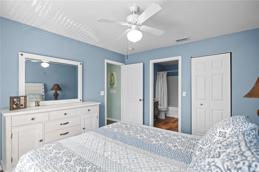 7417 Vista Way, Unit 202 Lakewood Ranch, FL 34202 - Photo 17 of 56 a bedroom with a large bed and a chandelier