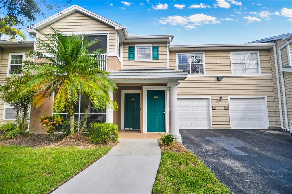 7417 Vista Way, Unit 202 Lakewood Ranch, FL 34202 - Photo 2 of 56 a front view of a house with a yard and potted plants