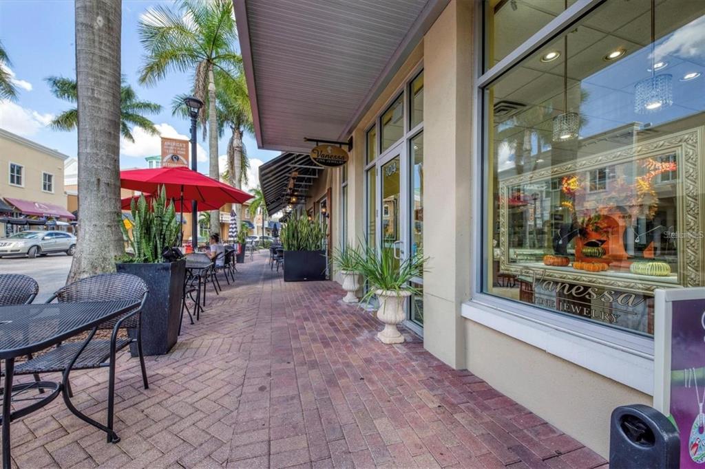 7417 Vista Way, Unit 202 Lakewood Ranch, FL 34202 - Photo 46 of 56 a view of a patio with a table and chairs under an umbrella