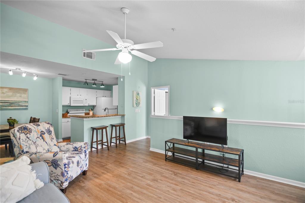 7417 Vista Way, Unit 202 Lakewood Ranch, FL 34202 - Photo 9 of 56 a living room with furniture and a flat screen tv