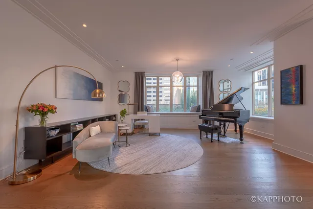 a living room with furniture a piano and a dining table