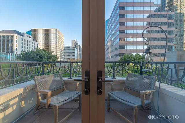 a view of a balcony with two chairs and a potted plant