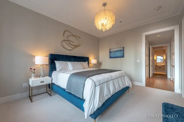 a bedroom with bed and a chandelier