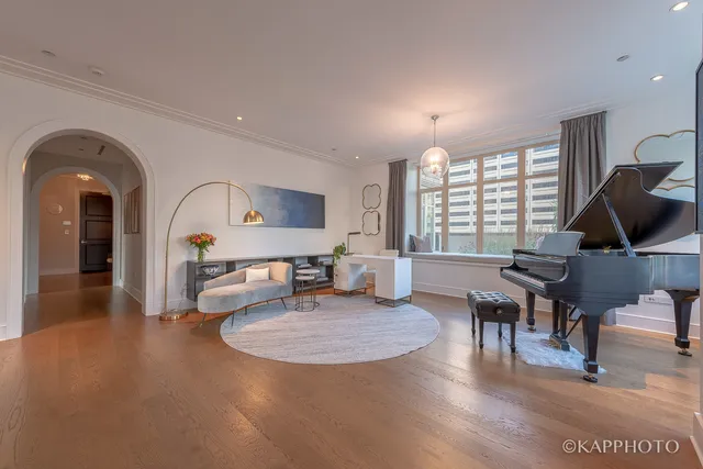 a living room with furniture a window and a dining table with wooden floor