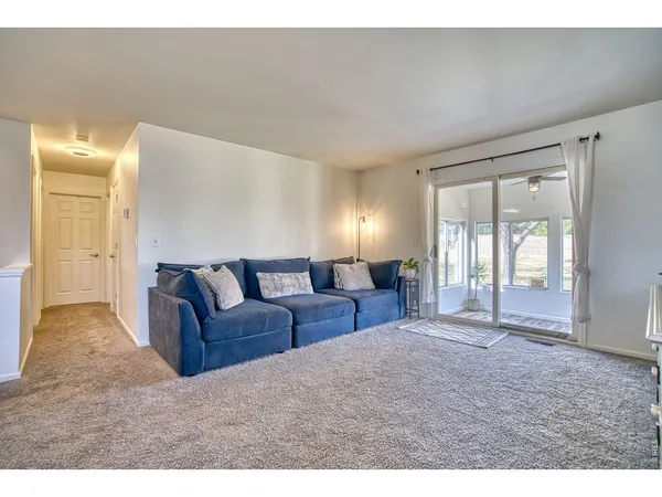 a living room with furniture and view of kitchen