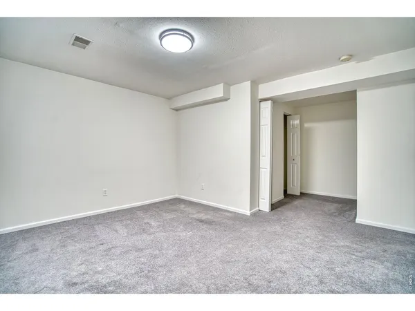 an empty room with windows and closet