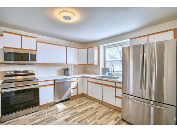 a kitchen with granite countertop a stove top oven sink and cabinets