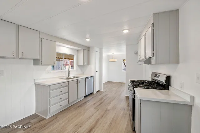 a kitchen with granite countertop a sink a counter space and cabinets