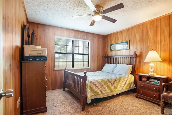 a bedroom with a bed chandelier and a window