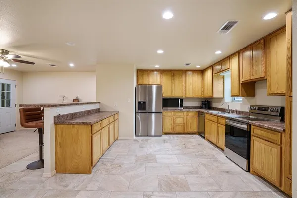 a large kitchen with stainless steel appliances kitchen island granite countertop a large counter top cabinets and stainless steel appliances