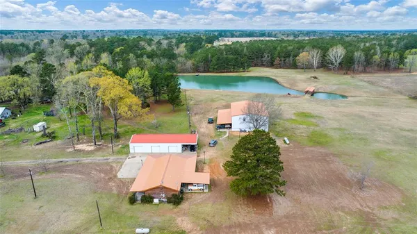 an aerial view of a house with a yard and lake view