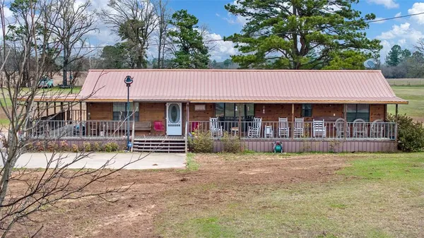 a view of house with a yard and sitting area