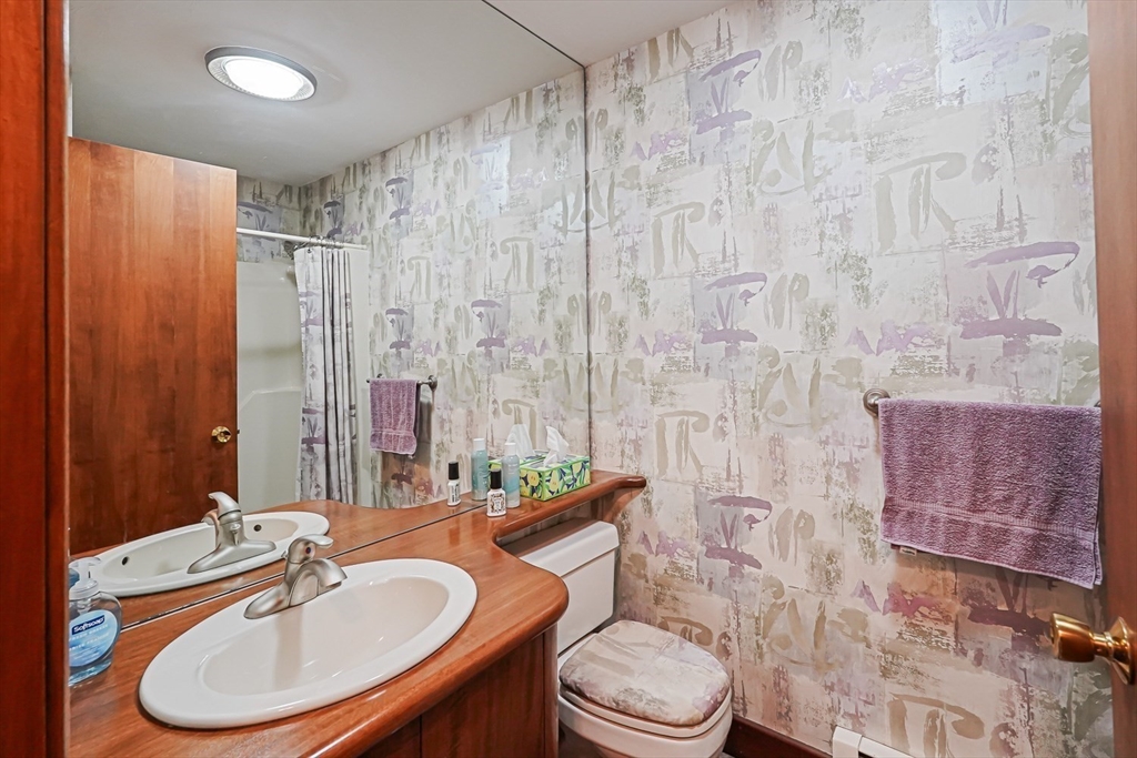 165 Barre Paxton Road Rutland, MA 01543 - Photo 26 of 42 a bathroom with a sink a toilet a mirror and shower curtain