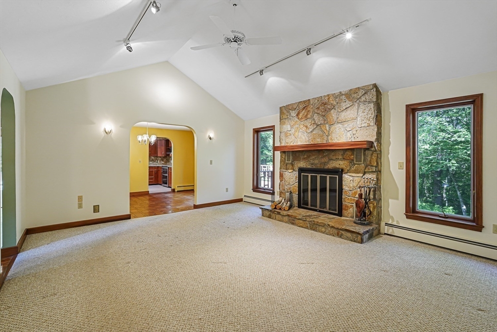 165 Barre Paxton Road Rutland, MA 01543 - Photo 8 of 42 an empty room with windows fireplace and a ceiling fan