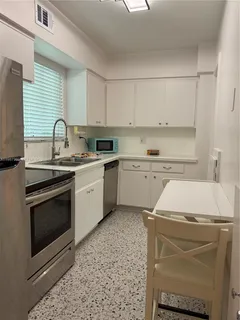 a kitchen with a sink cabinets and appliances