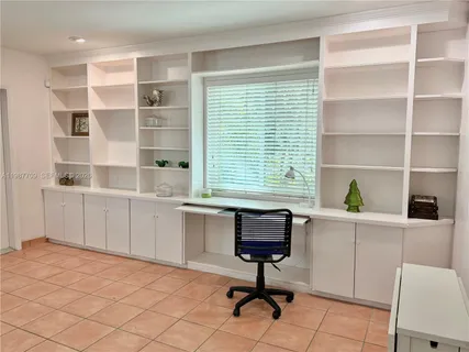 a view of a workspace with furniture and a window