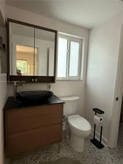 a bathroom with a toilet a sink and a mirror
