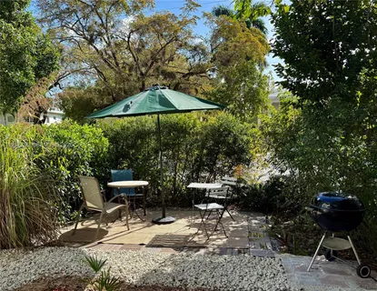 a view of backyard with seating space and trees