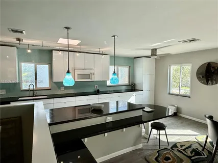a kitchen with a sink cabinets and window