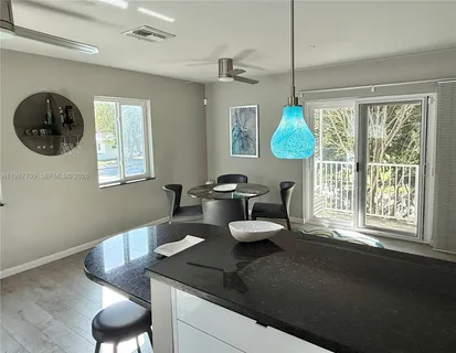 a kitchen with a table chairs and a window