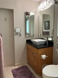 a bathroom with a sink a toilet and mirror