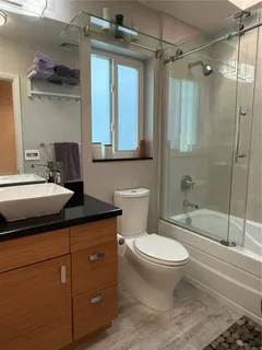a bathroom with a granite countertop sink toilet and shower