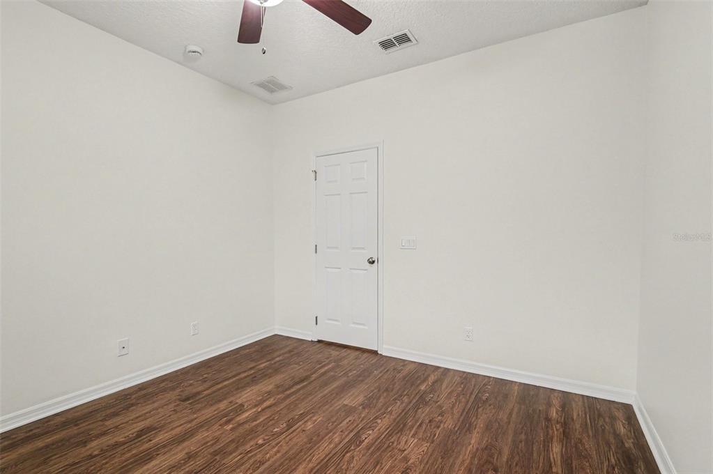 4819 Indian Deer Road Windermere, FL 34786 - Photo 21 of 30 an empty room with a ceiling fan and wooden floor