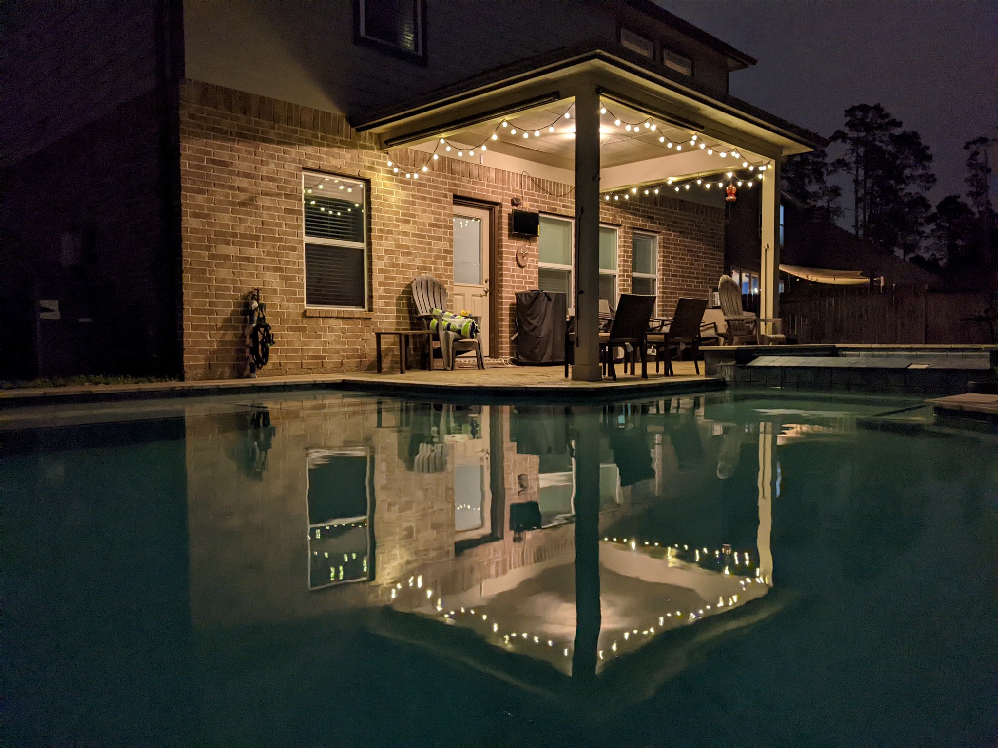 2672 Magnolia Fair Way Spring, TX 77386 - Photo 44 of 49 Charming night view of a cozy patio with twinkling string lights reflecting beautifully on the tranquil pool. Perfect for evening relaxation and entertaining.