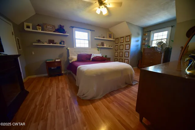 a bedroom with a bed and a flat tv screen on dresser