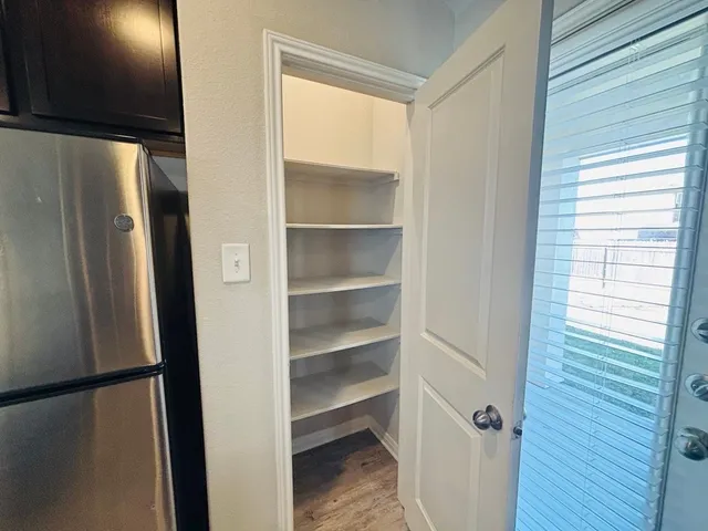 a view of walk in closet with empty racks