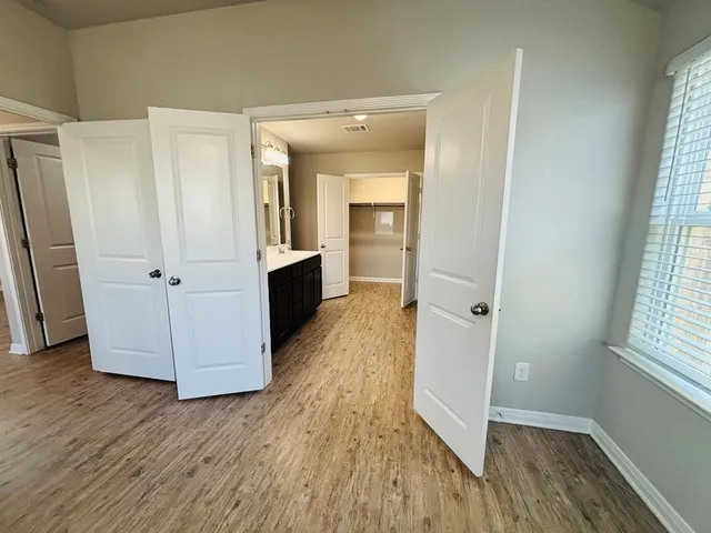 an entryway with wooden floor and cabinet