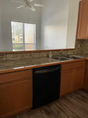 a view of a kitchen with wooden floor and a sink
