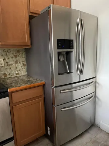 a metallic refrigerator freezer sitting in a kitchen