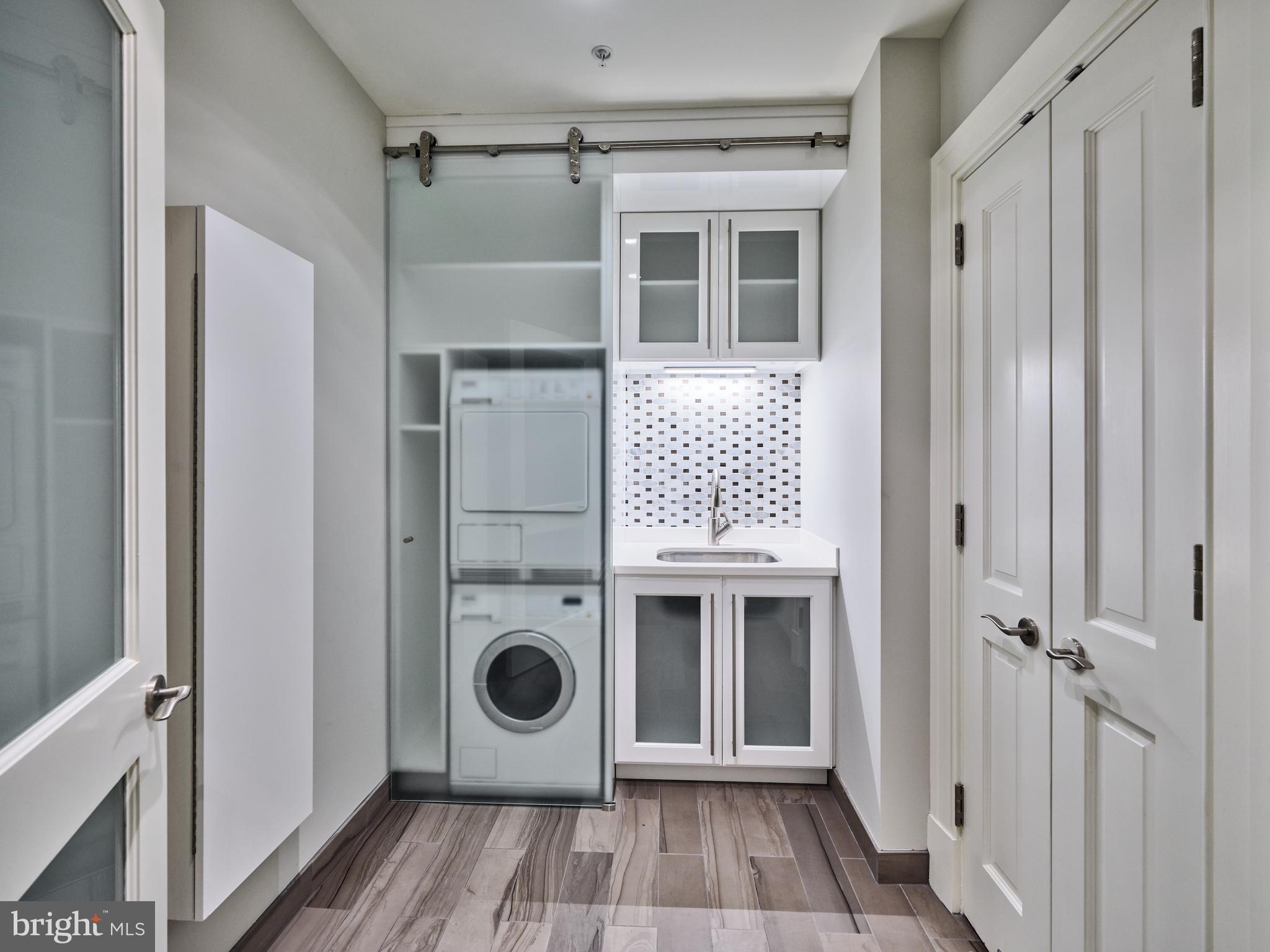130 South 18th Street, Unit 1602 Philadelphia, PA 19103 - Photo 18 of 52 a view of a hallway with washer and dryer