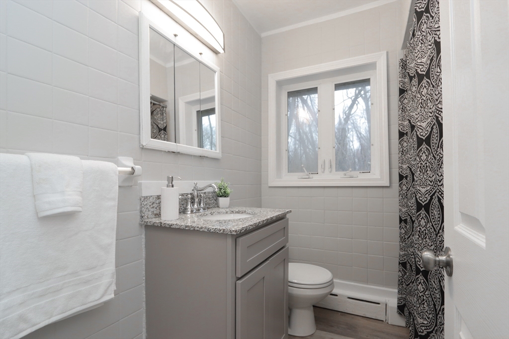 96 Almira Road Springfield, MA 01119 - Photo 21 of 38 a bathroom with a granite countertop toilet a sink and a mirror
