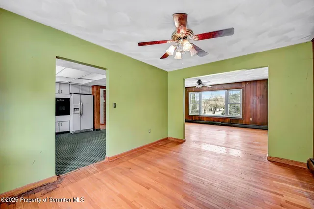a view of an empty room with window and wooden floor