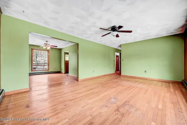 a view of a room with a chandelier fan and windows