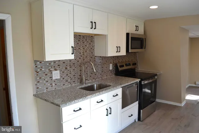 a kitchen with stainless steel appliances granite countertop a sink and a stove