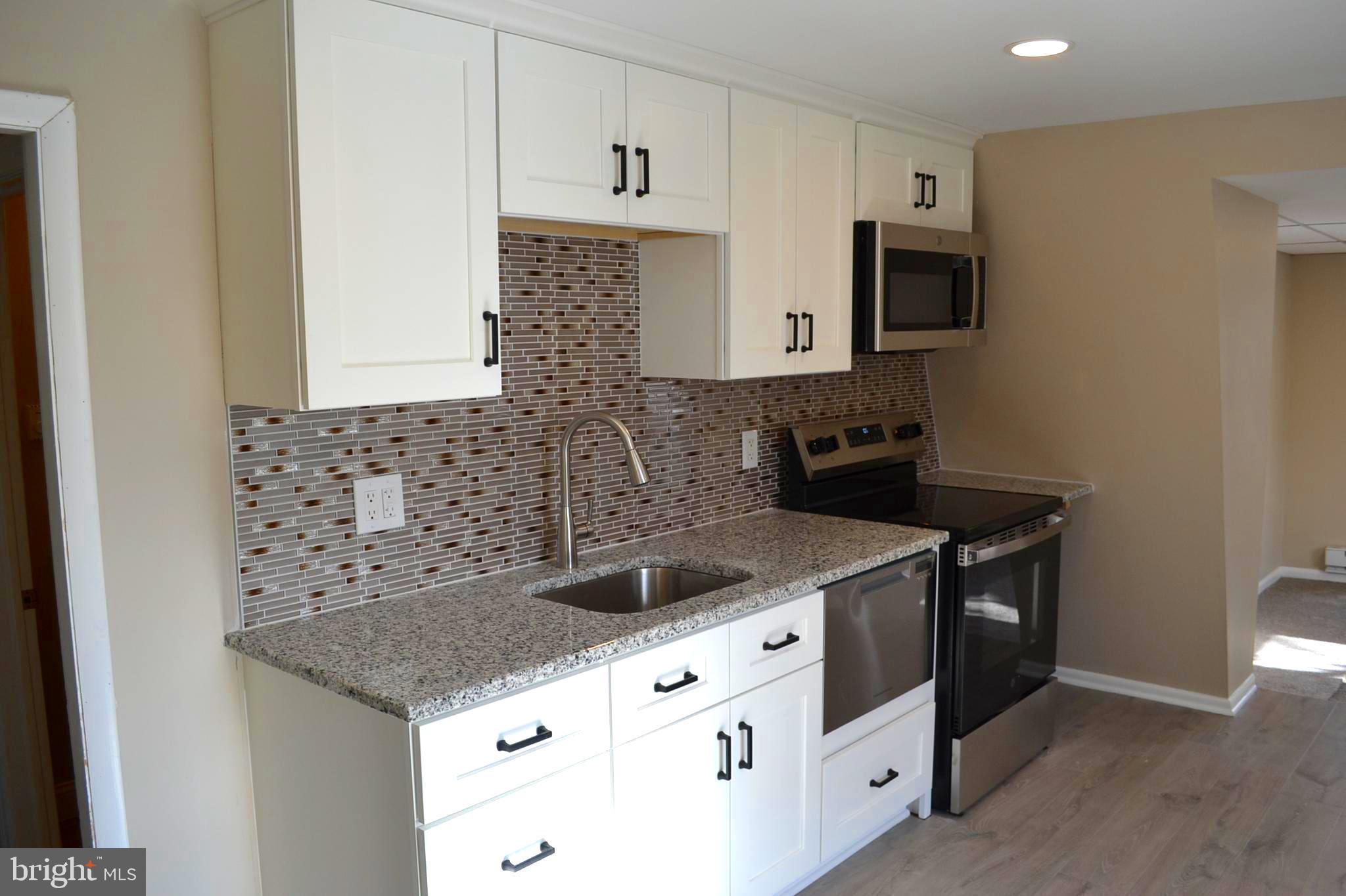 a kitchen with stainless steel appliances granite countertop a sink and a stove