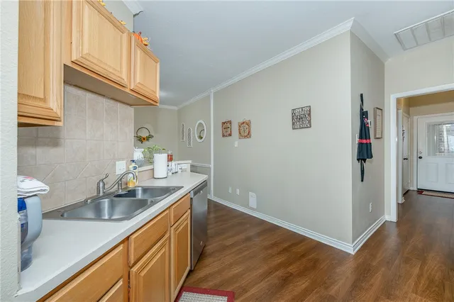 a kitchen with a sink cabinets and wooden floor