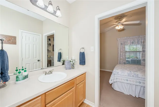 a en suite bathroom with a granite countertop sink and a mirror