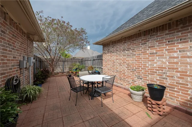 a view of a patio with table and chairs and potted plants