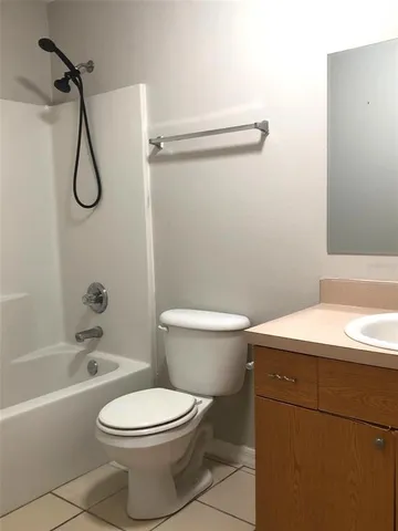 a bathroom with a toilet sink vanity and shower
