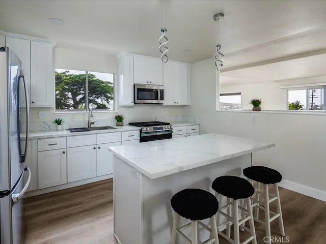 a kitchen with a dining table chairs stainless steel appliances and cabinets