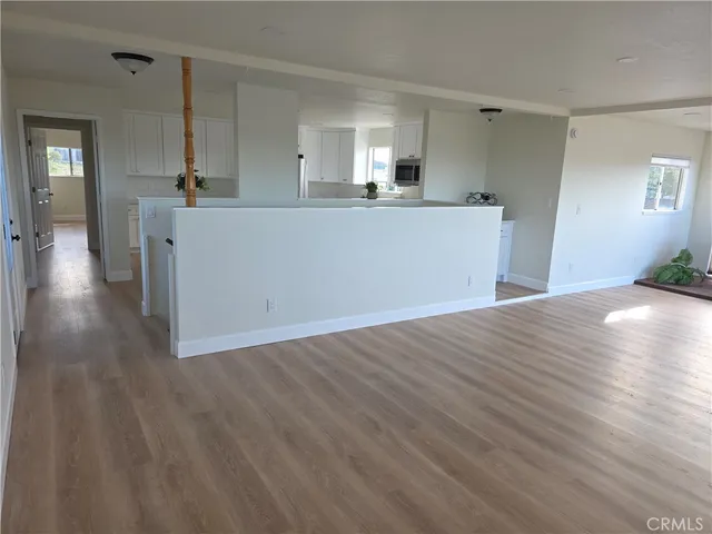a view of a kitchen with wooden floor and a sink