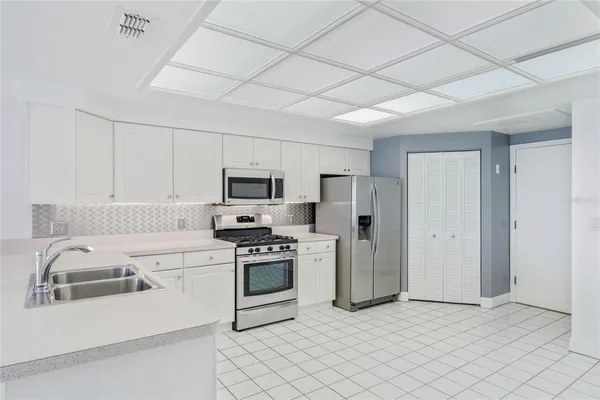 a kitchen with stainless steel appliances granite countertop a refrigerator a stove top oven a sink and dishwasher