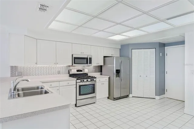 a kitchen with stainless steel appliances granite countertop a refrigerator a stove top oven a sink and dishwasher